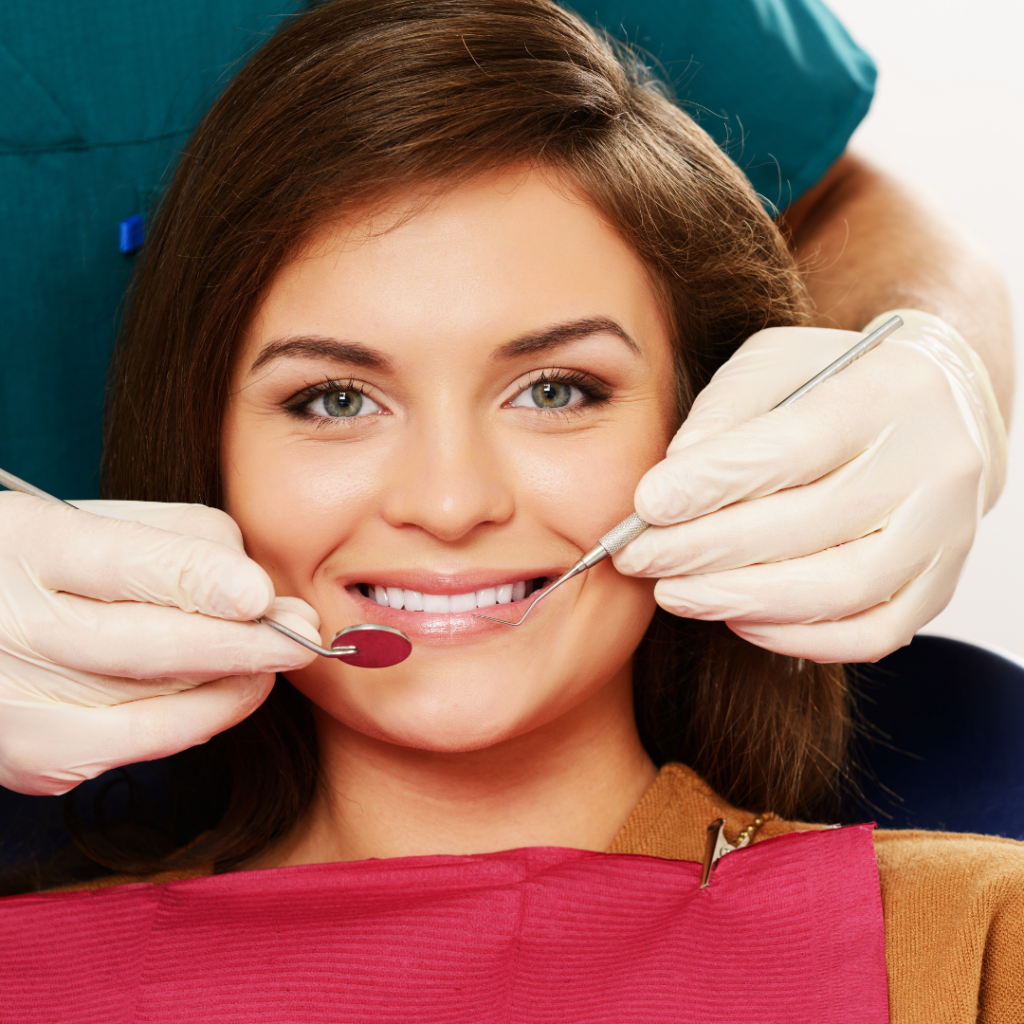 Woman smiling with dental instruments near her mouth